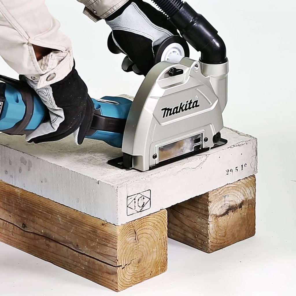 MAKITA Pölysuoja imuriliitännällä 125mm, Ø32/37mm, max.katkaisusyvyys 25 mm. Kuvassa sahataan betonia pölysuojavarustusta käyttäen.