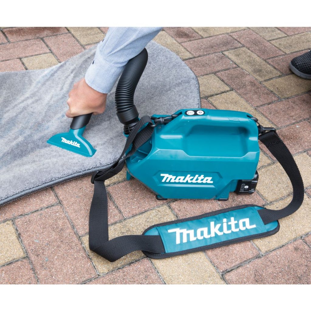 MAKITA Mattosuulake, vihreä. Kuvassa henkilö imuroimassa rikkaimurilla autotekstiilejä.