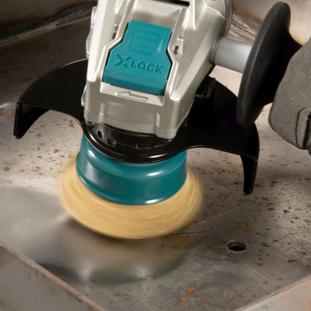 MAKITA Teräsharja 75 mm X-Lock. Kuvassa putsataan terästasoa kuppiharjalla.