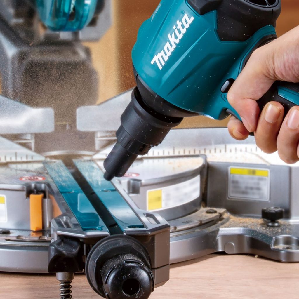 MAKITA Puhallussuutin, kapea. Kuvassa henkilö puhaltamassa sahanpuruja katkaisusahasta puhallussuuttimen avulla.