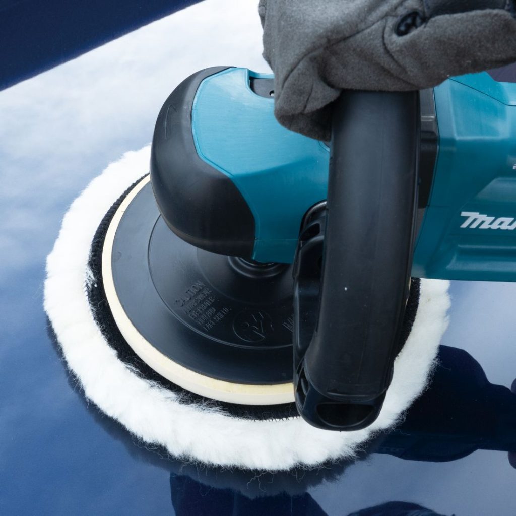 MAKITA Kiillotusmoppi 180 mm, villaa. Kuvassa henkilö vahaamassa autoa kiillotusmoppia käyttäen.