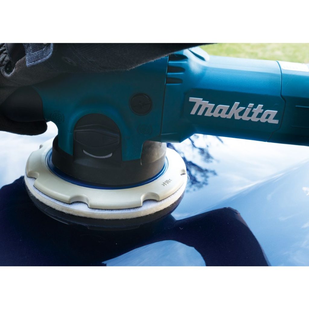 MAKITA Kiillotussieni 150 mm koukkutarrakiinnitys. Lähikuvassa henkilö vahaamassa autoa kiillotussienentä käyttäen.