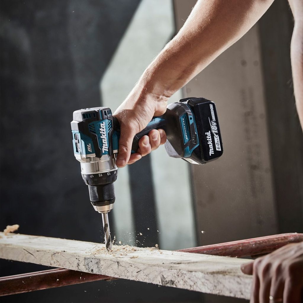 MAKITA Porakone LXT. Kuvassa henkilö poraamassa reikää lautaan.