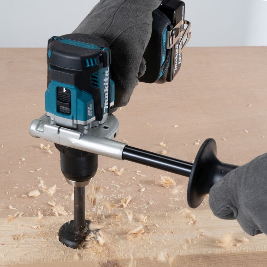 MAKITA Porakone LXT. Kuvassa henkilö poraamassa reikää leveään lankkuun.