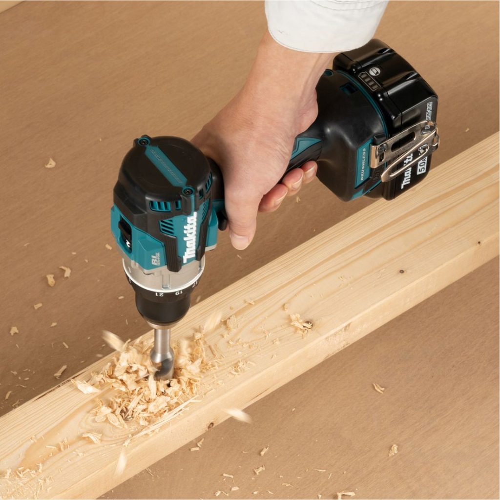 MAKITA Porakone LXT. Kuvassa henkilö poraamassa reikää lautaan.