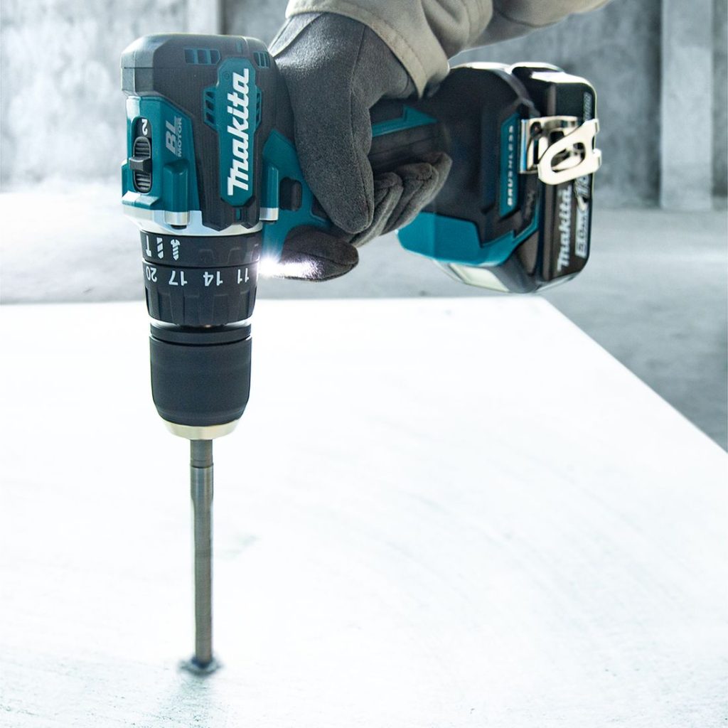 MAKITA Iskuporakone LXT. Kuvassa henkilö poraamassa reikää betoniin Iskuporakone LXT:n avulla.