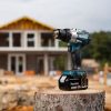 MAKITA Iskuporakone LXT. Kuvassa iskiporakone LXT kannon päällä työmaalla oikealta etuviistosta.