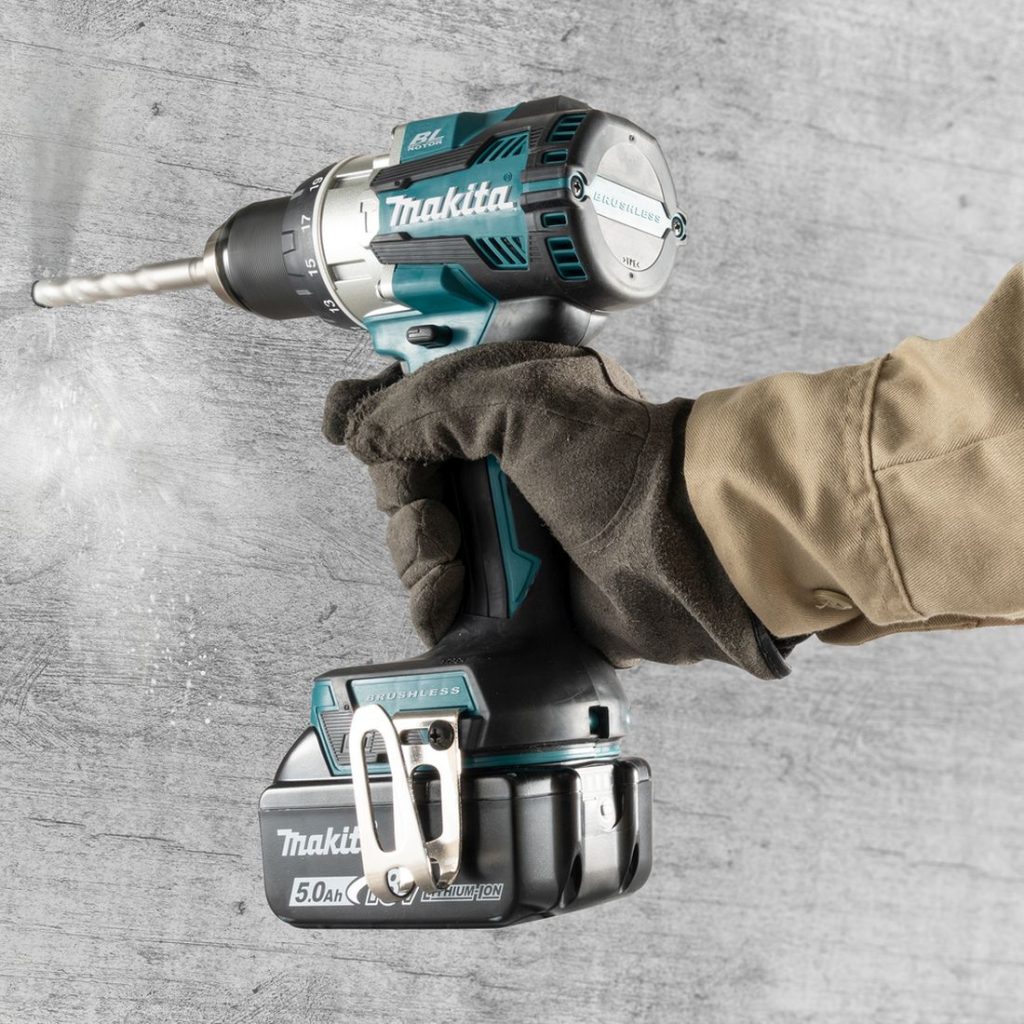MAKITA Iskuporakone LXT. Kuvassa henkilö poraamassa reikää betoniseinään iskiporakone LXT:n avulla.