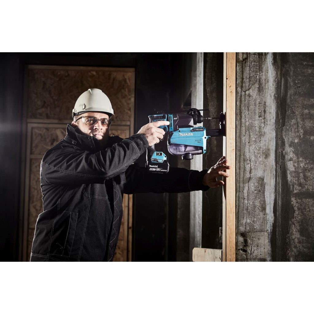 MAKITA Poravasara LXT. Kuvassa henkilö poraamassa reikää laudan läpi betoniseinään Poravasara LXT:n avulla.