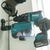 MAKITA Poravasara LXT. Kuvassa henkilö poraamassa reikää betoniseinään Poravasara LXT:n avulla.