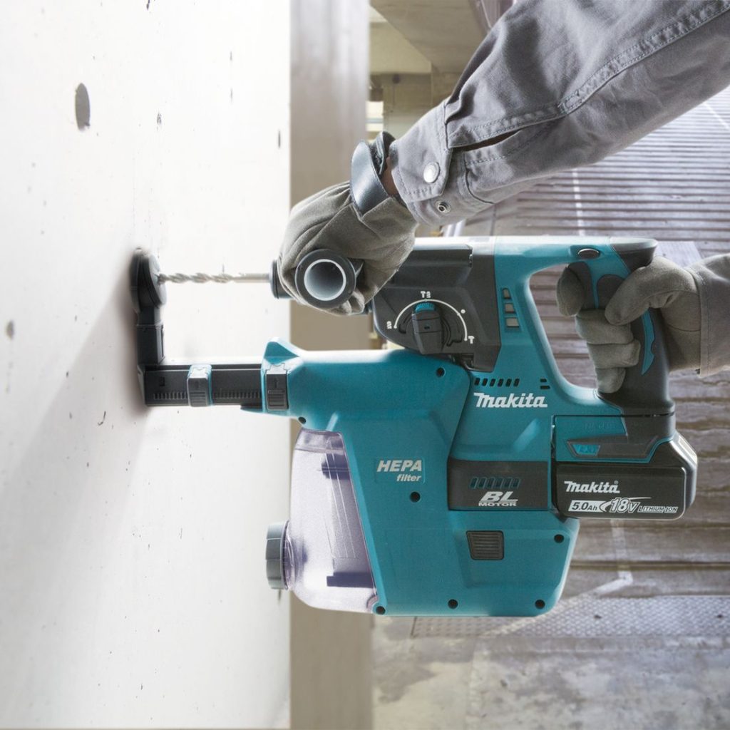 MAKITA Poravasara LXT. Kuvassa henkilö poraamassa reikää betoniseinään Poravasara LXT:n avulla.