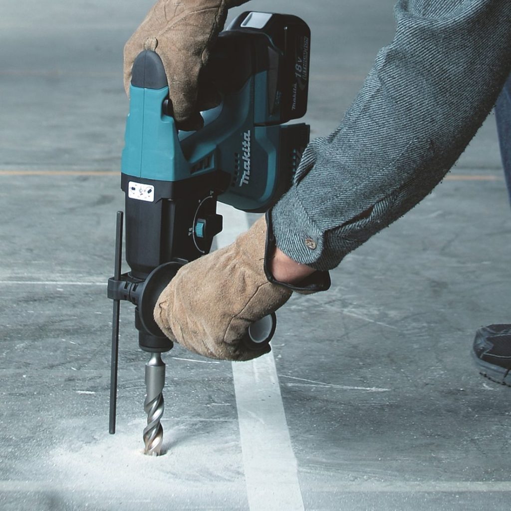 MAKITA Poravasara LXT. Kuvassa henkilö poraamassa reikää betonilattiaan Poravasara LXT:n avulla.