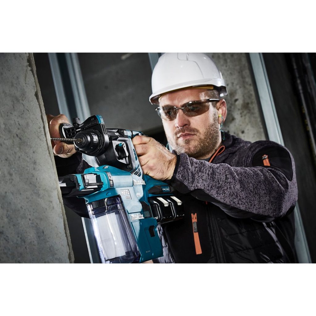 MAKITA Poravasara LXT. Kuvassa henkilö poraamassa betoniseinään reikää Poravasara LXT:n avulla.