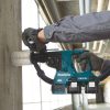 MAKITA Poravasara LXT. Kuvassa henkilö poraamassa betoniseinään reikää Poravasara LXT:n avulla pölykuppia käyttäen.