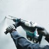 MAKITA Poravasara LXT. Kuvassa henkilö poraamassa reikää betoniseinään Poravasara LXT:n avulla.