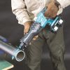 MAKITA Puukkosaha LXT. Kuvassa henkilö katkaisemassa teräsputkea Puukkosaha LXT:n avulla.