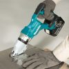 MAKITA Levyleikkuri LXT. Kuvassa henkilö leikkaamassa peltilevyä Levyleikkuri LXT:n avulla.
