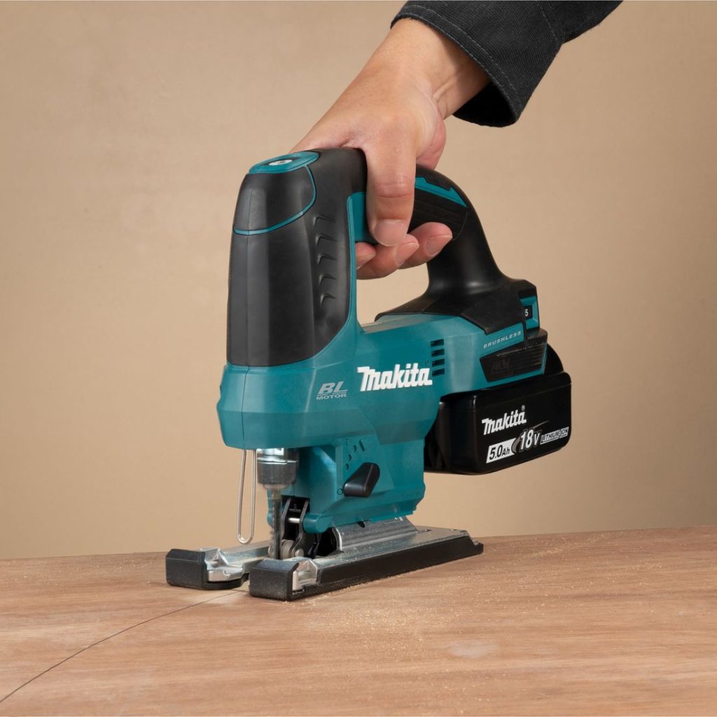 MAKITA Pistosaha LXT. Kuvassa henkilö sahaamassa kaarta vanerilevyyn Pistosaha LXT:n avulla.