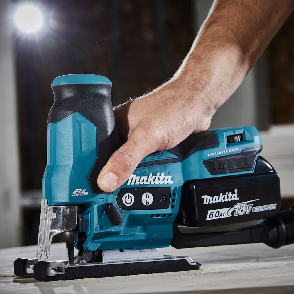MAKITA Pistosaha LXT. Lähikuvassa henkilö sahaamassa vanerilevyä Pistosaha LXT:n avulla.