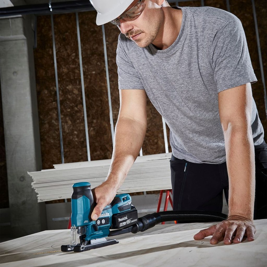 MAKITA Pistosaha LXT. Kuvassa henkilö sahaamassa ympyrää vanerilevyyn Pistosaha LXT:n avulla.