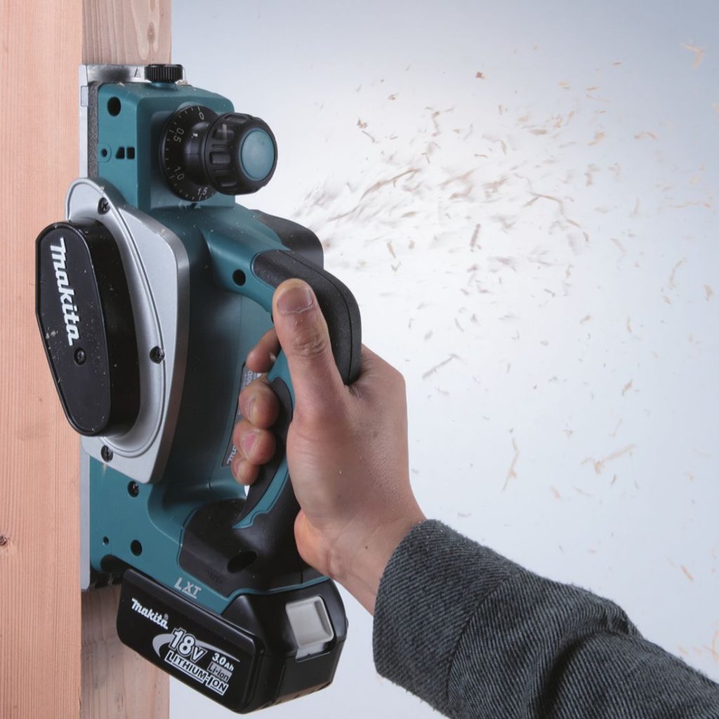 MAKITA Höylä LXT. Kuvassa henkilö höyläämässä runkotolppaa höylä LXT:n avulla.