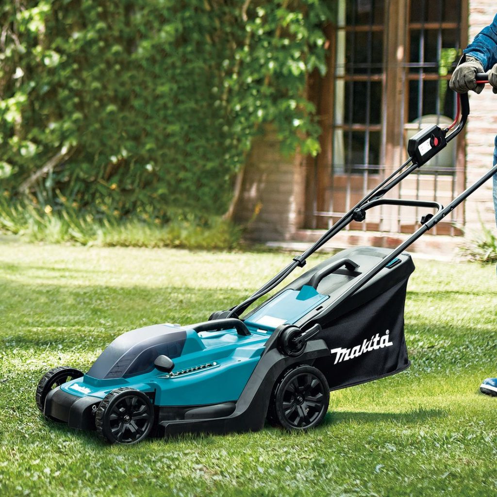 MAKITA Ruohonleikkuri LXT. Kuvassa henkilö leikkaamassa ruohoa ruohonleikkuri LXT:n avulla.