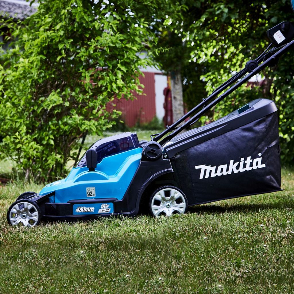 MAKITA Ruohonleikkuri LXT. Kuvassa henkilö leikkaamassa ruohoa ruohonleikkuri LXT:n avulla.