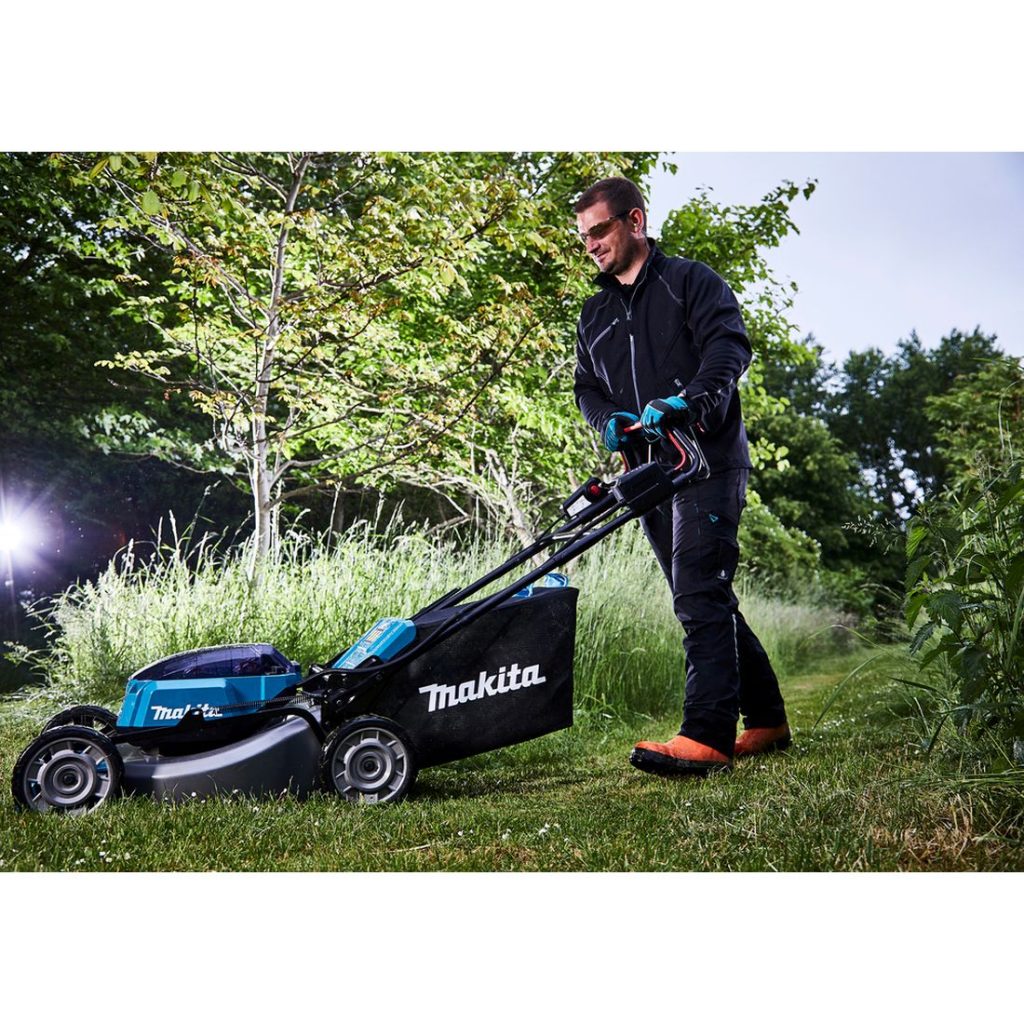 MAKITA Ruohonleikkuri LXT. Kuvassa henkilö leikkaamassa ruohoa ruohonleikkuri LXT:n avulla.