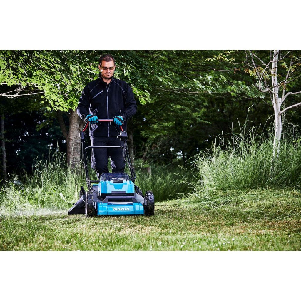 MAKITA Ruohonleikkuri LXT. Kuvassa henkilö leikkaamassa ruohoa ruohonleikkuri LXT:n avulla.
