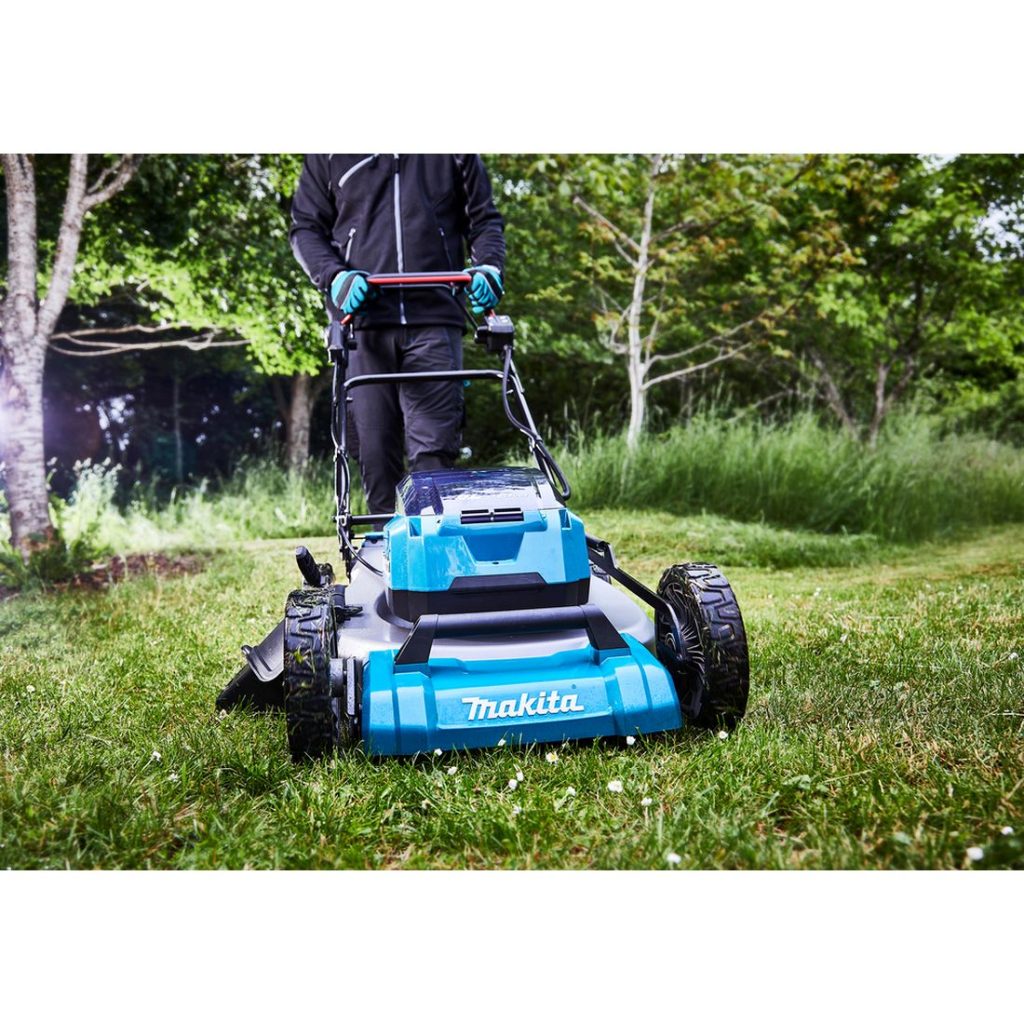 MAKITA Ruohonleikkuri LXT. Kuvassa henkilö leikkaamassa ruohoa ruohonleikkuri LXT:n avulla.
