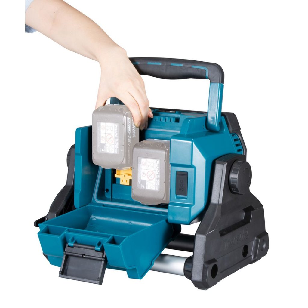 MAKITA LED-valaisin LXT. Kuvassa henkilö asentamassa akkua LED-valaisimeen.
