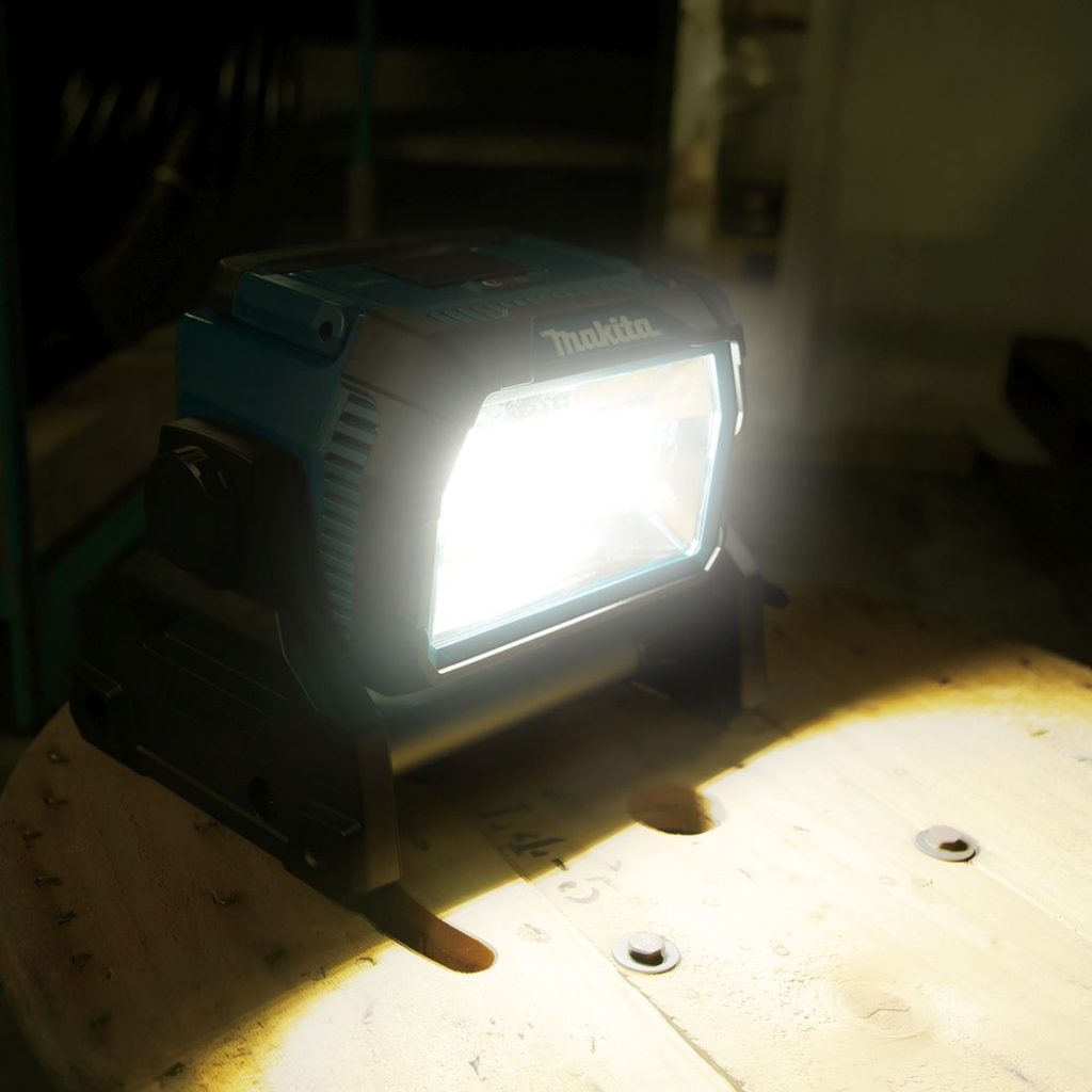 MAKITA LED-valaisin LXT. Kuvassa LED-valaisin LXT vasemmalta etuyläviistosta pimeässä valaisin päällä.