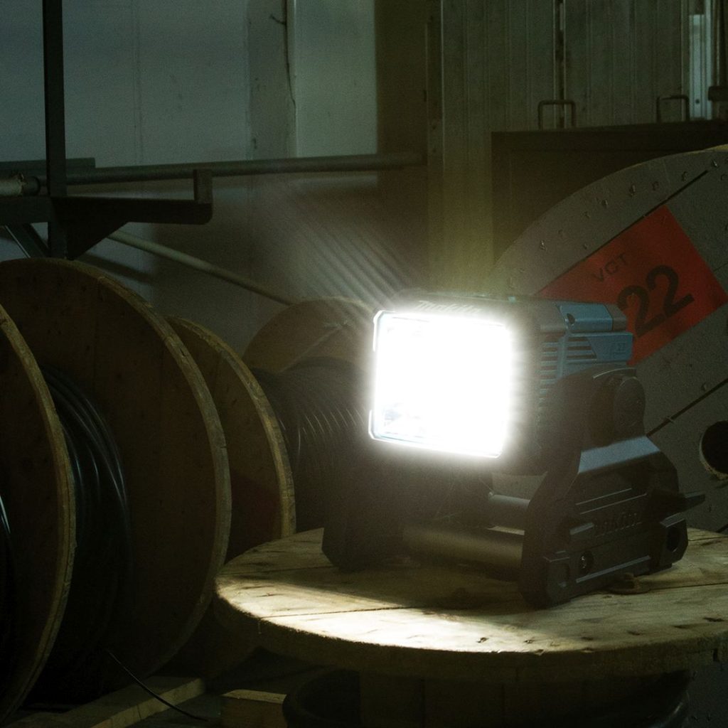 MAKITA LED-valaisin LXT. Kuvassa LED-valaisin LXT pimeässä valaisin päällä oikealta etuviistosta.