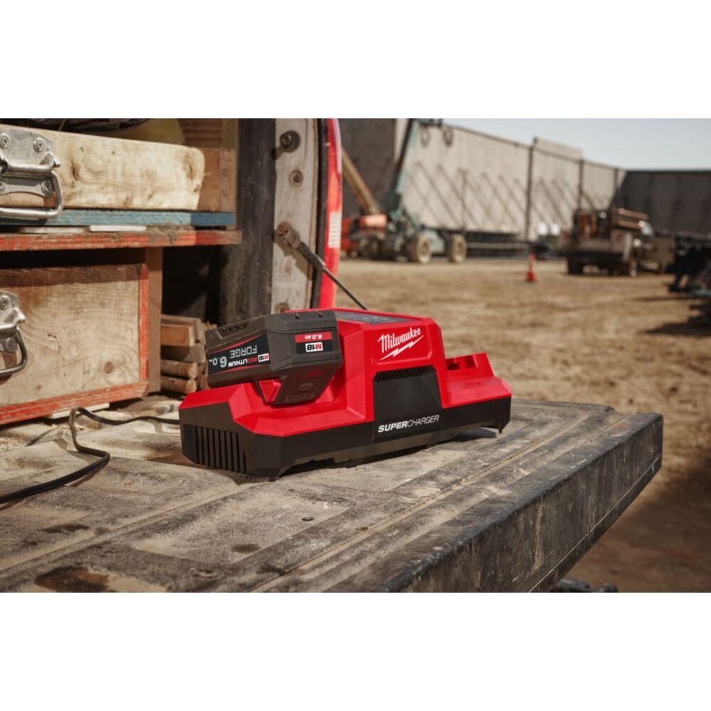 Milwaukee M18 FORGE DBSC 2-paikkainen pikalaturi. Kuvassa pikalaturi auton perälaudalla vasemmalta etuviistosta.