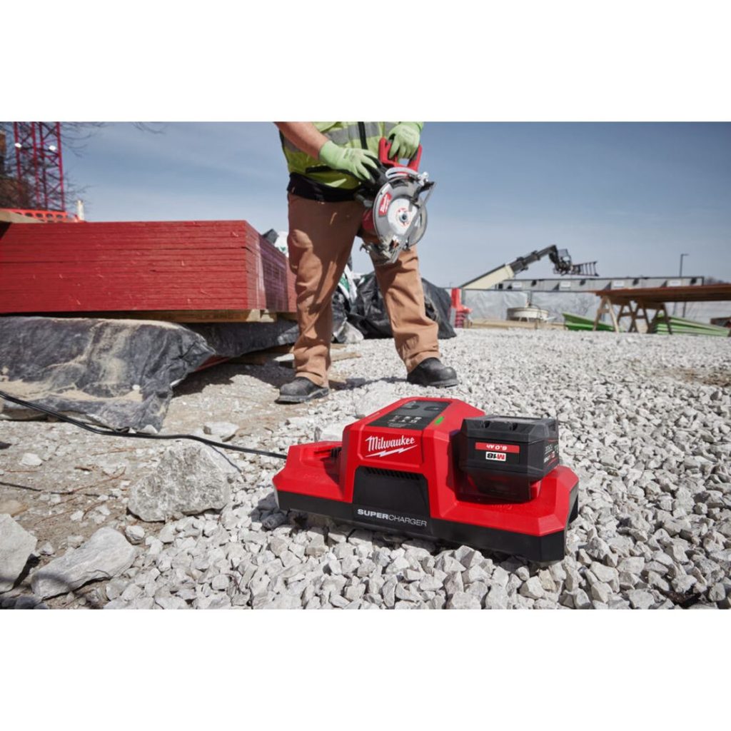 Milwaukee M18 FORGE DBSC 2-paikkainen pikalaturi. Kuvassa pikalaturi työmaalla soramaassa oikealta etuviistosta.