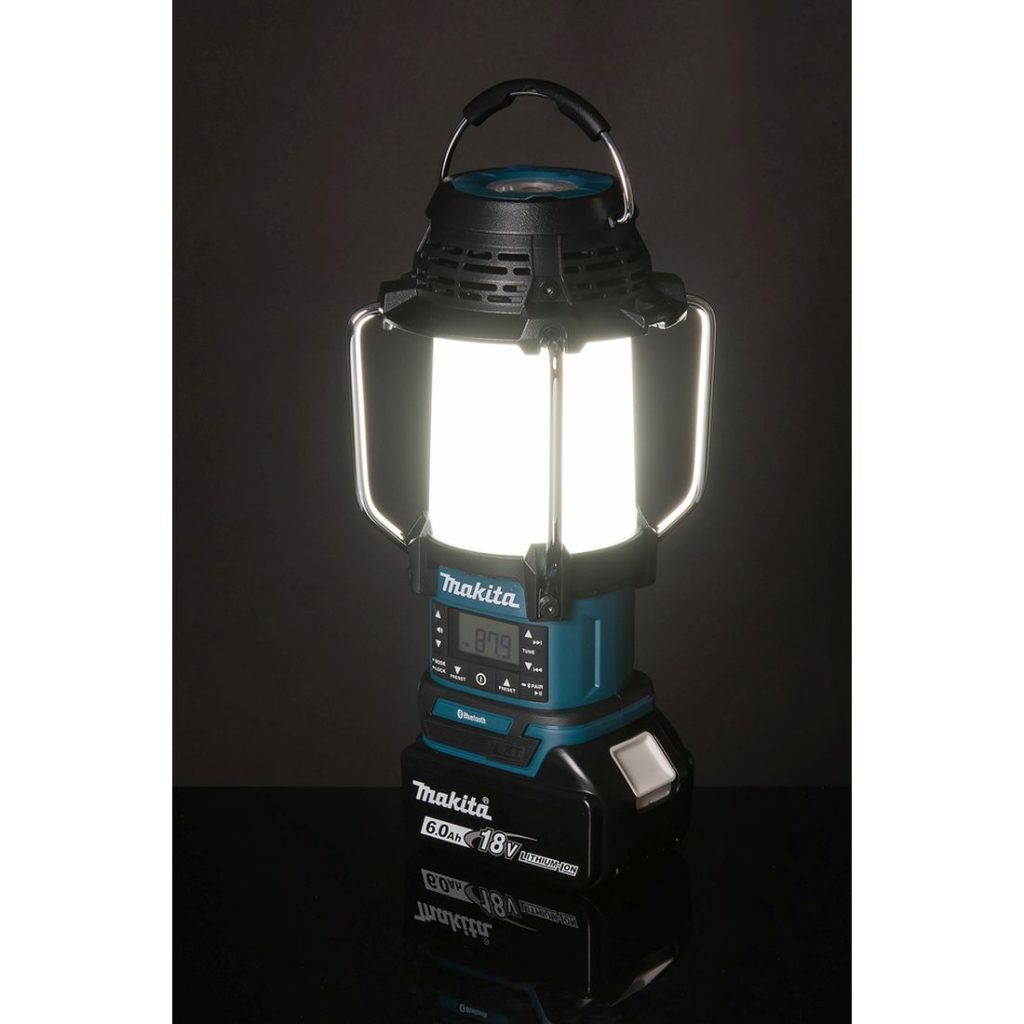 MAKITA Lyhty / Radio / Kaiutin LXT. Kuvassa Lyhty / Radio / Kaiutin LXT valaisin päällä sivusuunnassa pimeässä vasemmalta etuviistosta.