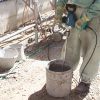 MAKITA Pora- ja sekoituskone. Kuvassa henkilö sekoittamassa betonia ämpärissä pora- ja sekoituskoneen avulla.
