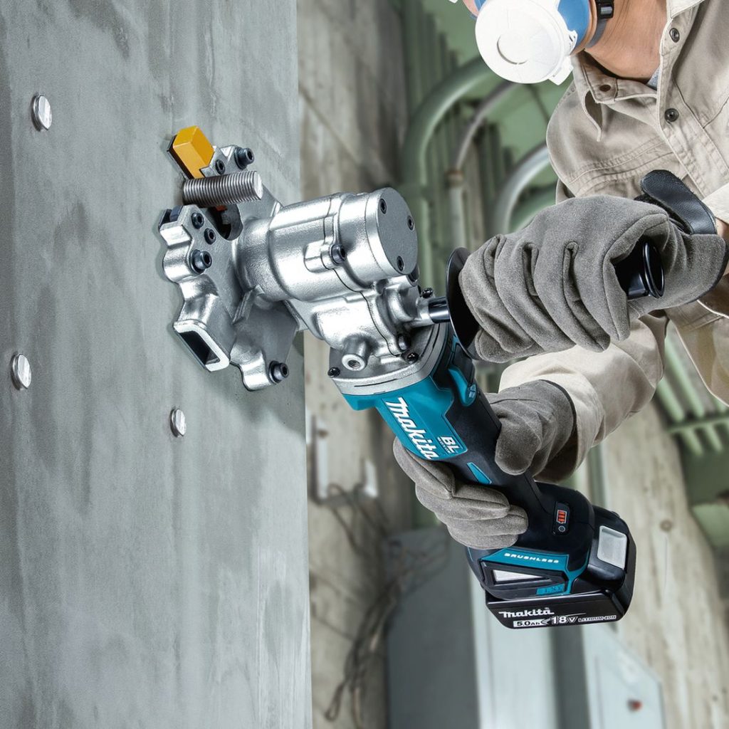 MAKITA Kierretanko- ja harjaterässaha LXT. Kuvassa hrnkilö katkaisemassa betoniseinässä olevaa kierretankoa Kierretanko- ja harjaterässaha LXT:n avulla.