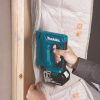 MAKITA Nitoja LXT. Kuvassa henkilö kiinnittämässä höyrynsulkumuovia puurunkoon Nitoja LXT:n avulla.