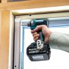 MAKITA Iskevä ruuvinväännin LXT. Kuvassa henkilö asentamassa ikkunan karmia runkoon iskevän ruuvinväännin LXT:n avulla.