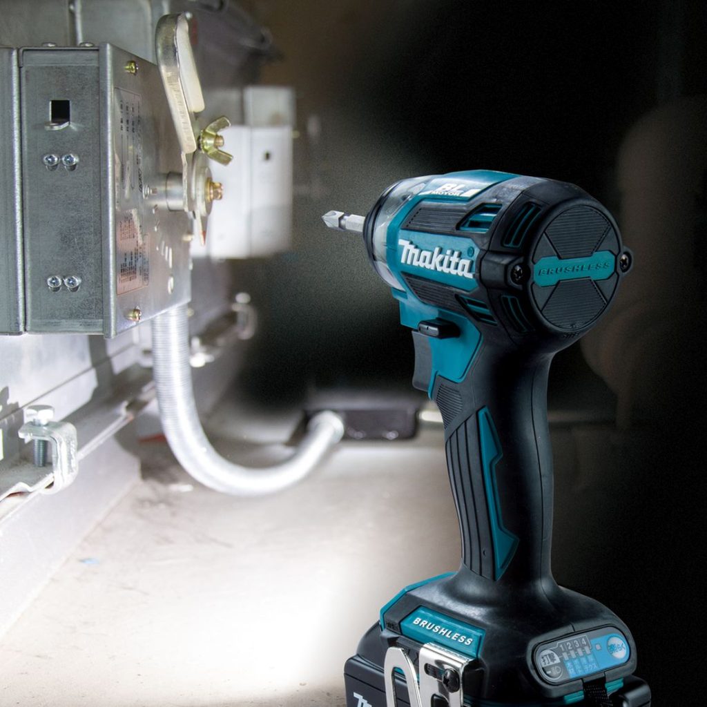 MAKITA Iskevä ruuvinväännin LXT. Kuvassa Iskevä ruuvinväännin LXT vasemmalta takaviistosta hämärässä integroitu LED-valo päällä.
