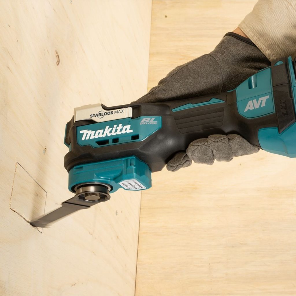 MAKITA Monitoimikone LXT. Kuvassa henkilö sahaamassa vaneriin suorakaiteen muotoista aukkoa Monitoimikone LXT:n avulla.