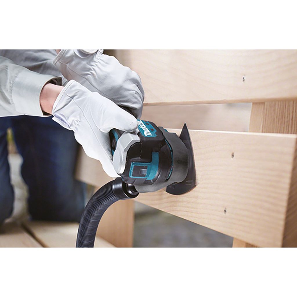 MAKITA Monitoimikone LXT. Kuvassa henkilö hiomassa puisen penkin selkänojaa Monitoimikone LXT:n avulla.