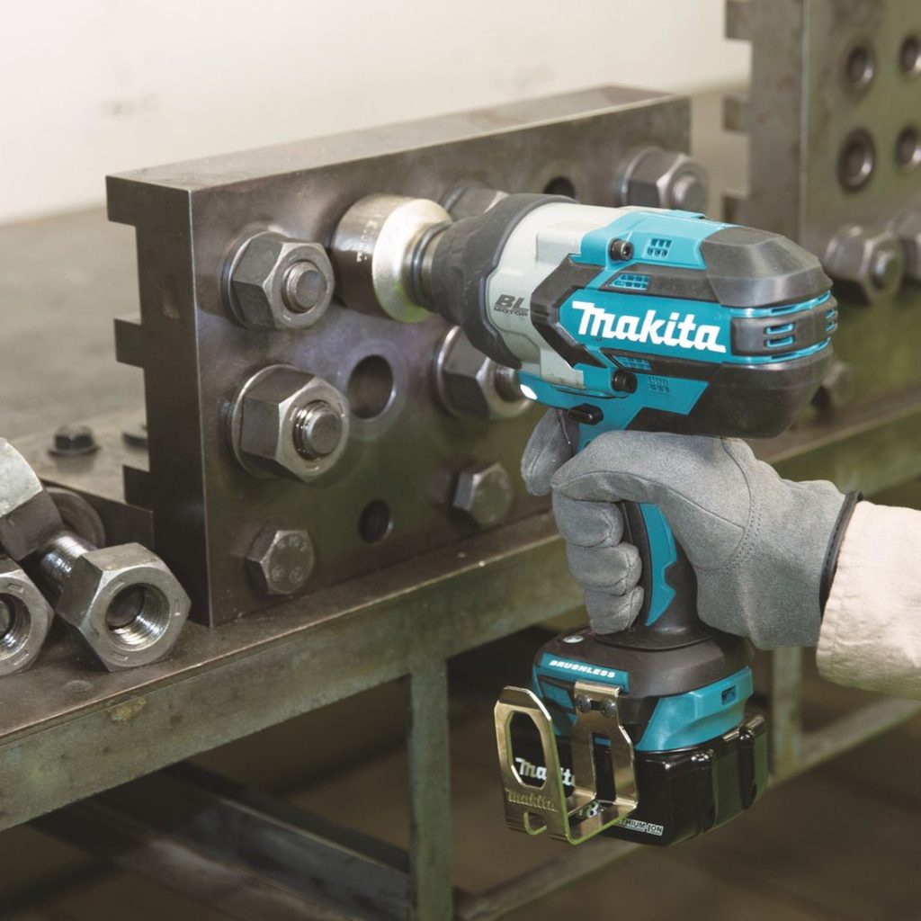 MAKITA Iskevä mutterinväännin LXT. Kuvassa henkilö kiristämässä isoja muttereita teräslevyyn Iskevä mutterinväännin LXT:n avulla.