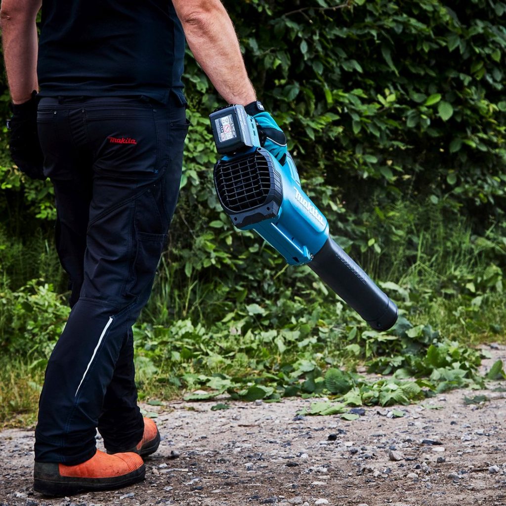 MAKITA Puhallin LXT. Kuvassa henkilö kantaa Puhallin LXT:tä kädessään.