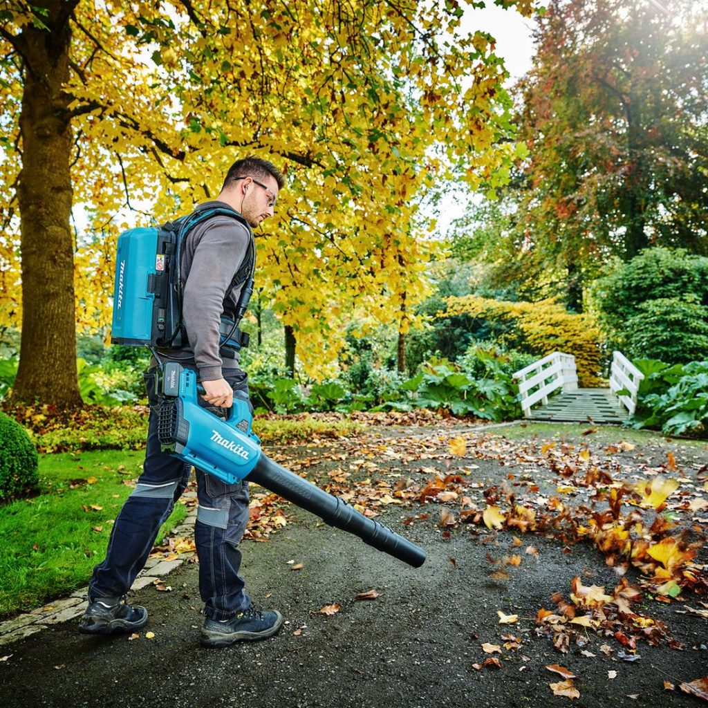 MAKITA Puhallin LXT. Kuvassa henkilö puhaltamassa puunlehtiä Puhallin LXT:: avulla.