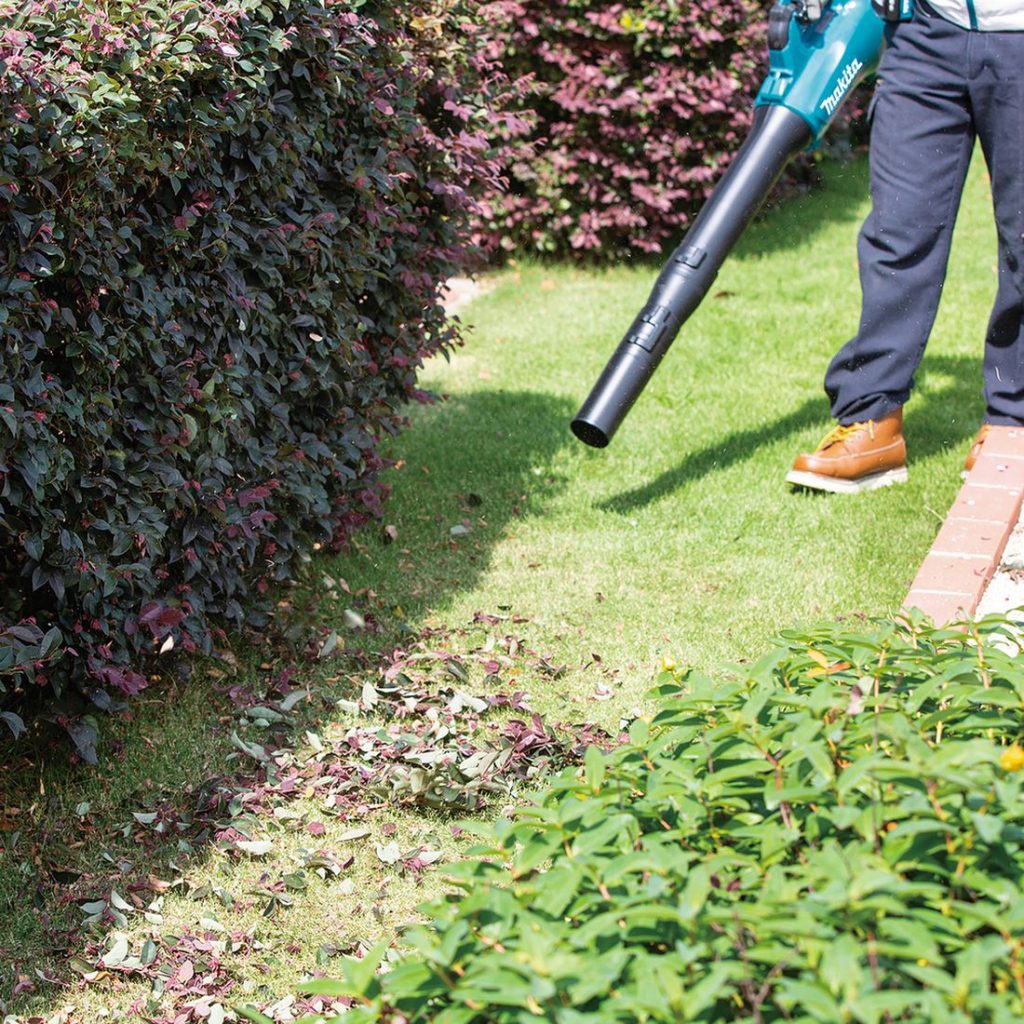 MAKITA Puhallin LXT. Kuvassa henkilö puhaltamassa puunlehtiä Puhallin LXT:: avulla.