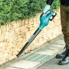 MAKITA Puhallin LXT. Kuvassa henkilö puhaltamassa roskia kivilaatoista Puhallin LXT:n avulla.