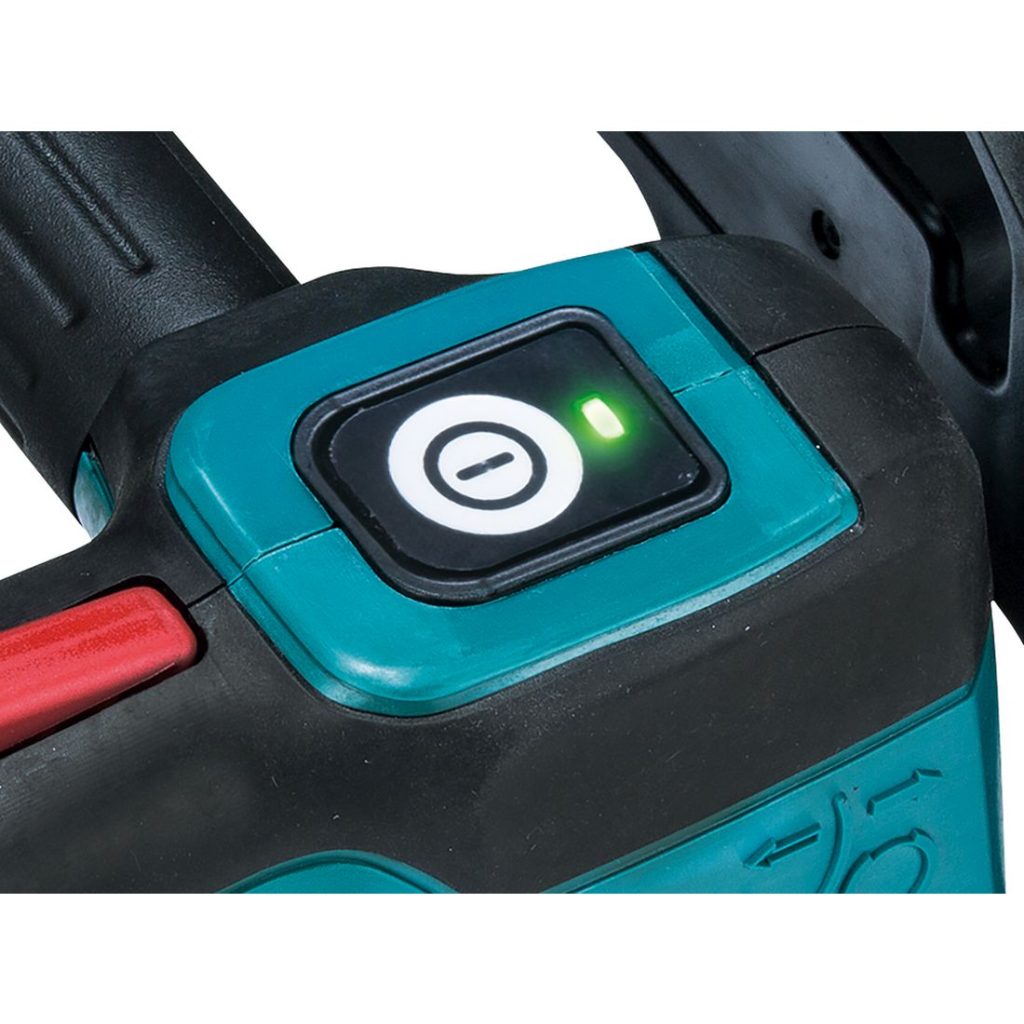 MAKITA Ketjusaha LXT. Lähikuvassa Ketjusaha LXT:n virtakytkin. Virtakytkimen valo palaa vihreänä.