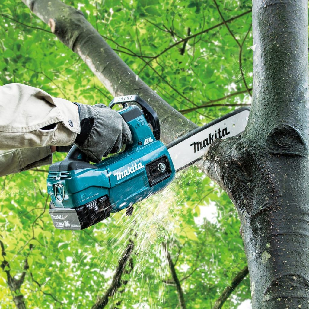 MAKITA Ketjusaha LXT. Kuvassa henkilö sahaamassa puun oksaa Ketjusaha LXT:n avulla.